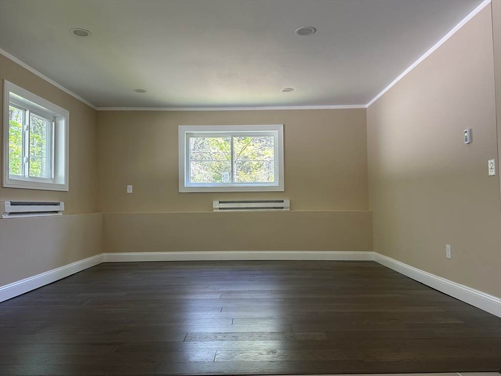 102 Wells Road Becket, MA 01223 - Photo 22 of 40 an empty room with wooden floor and windows