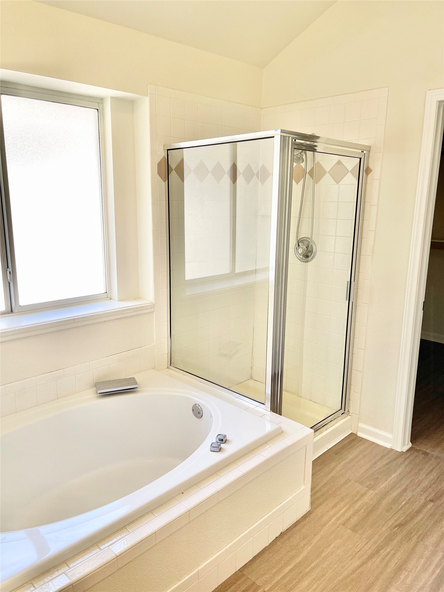 12513 Wethersby Way Austin, TX 78753 - Photo 10 of 16 Bathroom with a stall shower, a bath, lofted ceiling, and light wood-style flooring