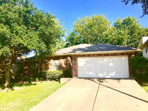 a view of backyard with wooden fence and a large tree
