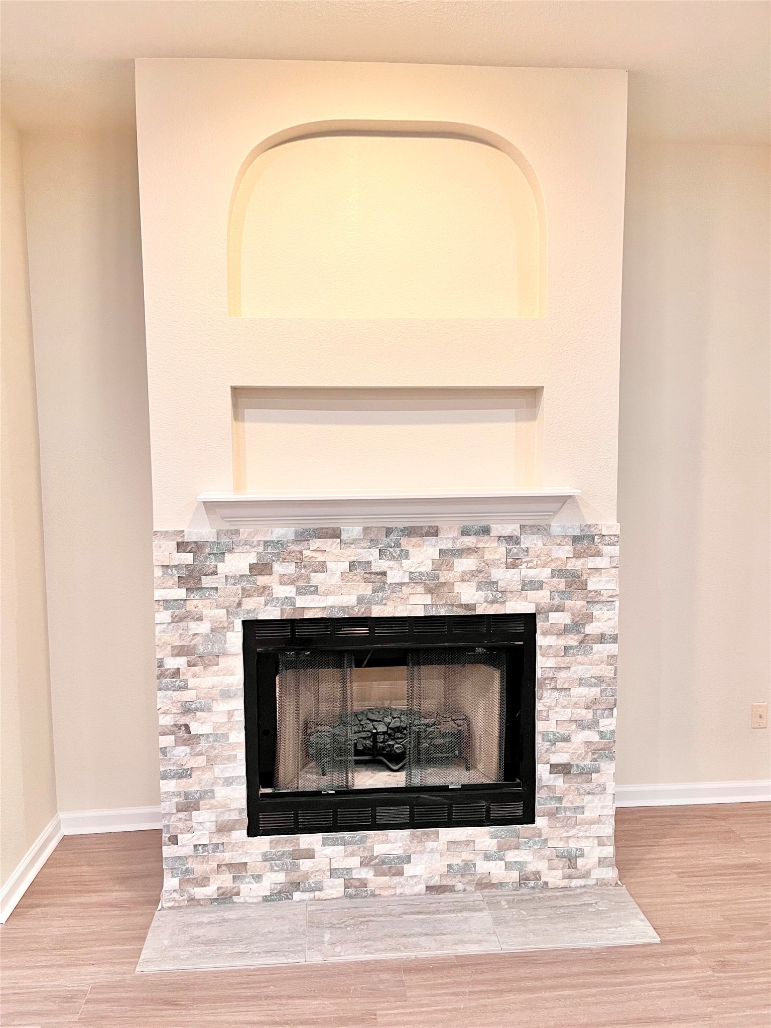12513 Wethersby Way Austin, TX 78753 - Photo 7 of 16 Detailed view of a stone fireplace and wood finished floors