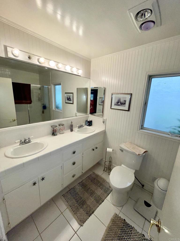2357 Vía Monserate Fallbrook, CA 92028 - Photo 16 of 28 a spacious bathroom with a double vanity sink a mirror and a toilet