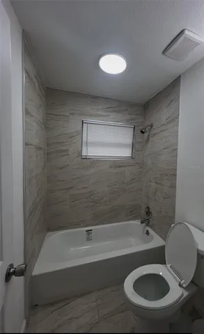 a bathroom with a sink a toilet and bathtub