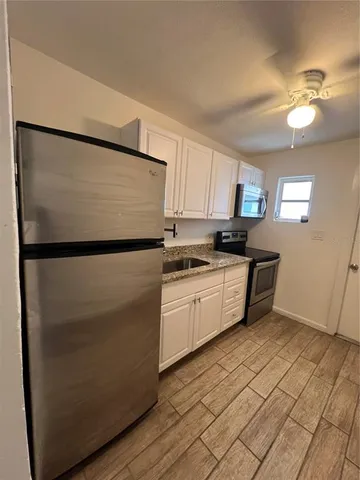 a kitchen with stainless steel appliances granite countertop a refrigerator sink and cabinets