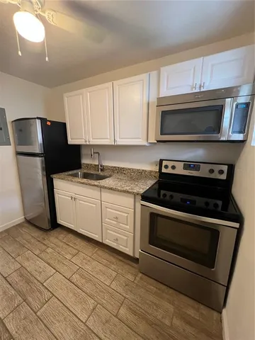 a kitchen with a sink stove and refrigerator