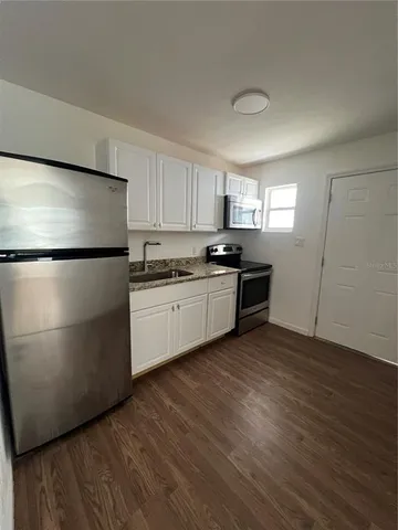 a kitchen with a refrigerator a sink and dishwasher a oven with wooden floors