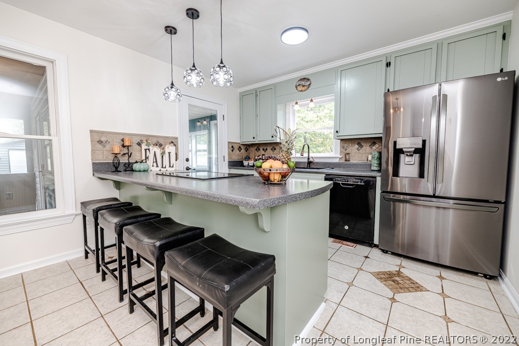 110 Cypress Road Cameron, NC 28326 - Photo 11 of 35 a kitchen with stainless steel appliances granite countertop a refrigerator a sink dishwasher a dining table and chairs with wooden floor