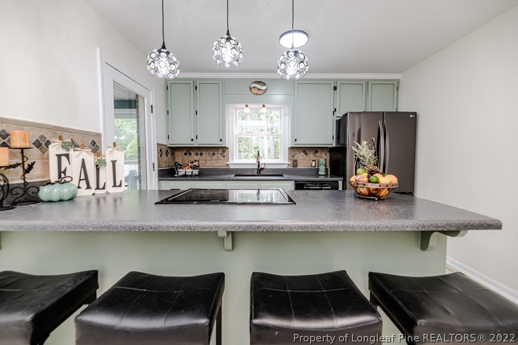 110 Cypress Road Cameron, NC 28326 - Photo 12 of 35 a kitchen with granite countertop a stove a sink and a wooden cabinets