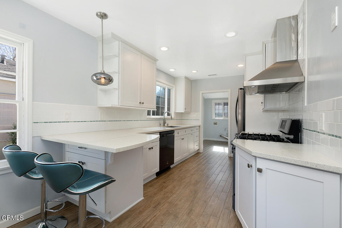 1060 West Roses Road San Gabriel, CA 91775 - Photo 5 of 12 a kitchen with a sink a stove a refrigerator and chairs