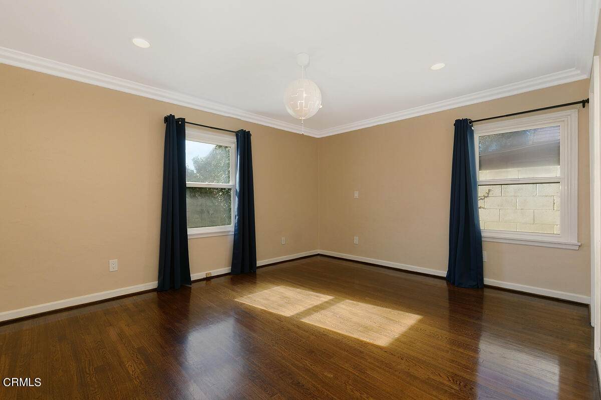 1060 West Roses Road San Gabriel, CA 91775 - Photo 7 of 12 an empty room with wooden floor and windows