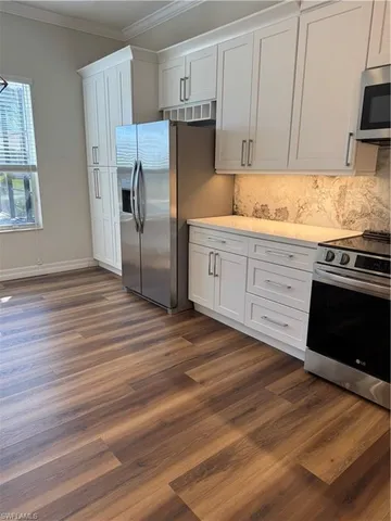 a kitchen with a refrigerator stove and wooden cabinets