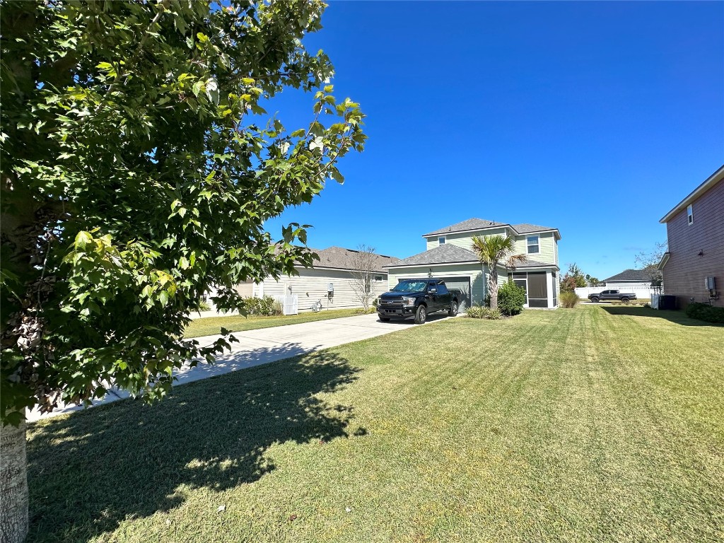 323 Sweetgum Street Yulee, FL 32097 - Photo 19 of 29 a tall yellow house with a yard