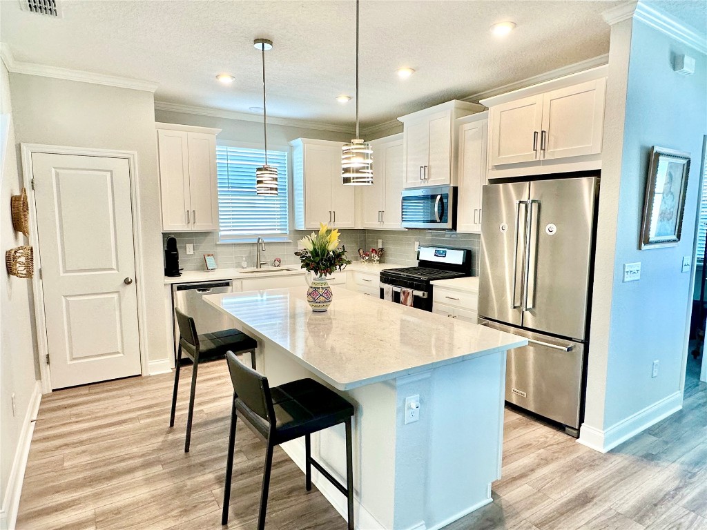 323 Sweetgum Street Yulee, FL 32097 - Photo 3 of 29 a kitchen with stainless steel appliances granite countertop a refrigerator a sink a stove a dining table and chairs