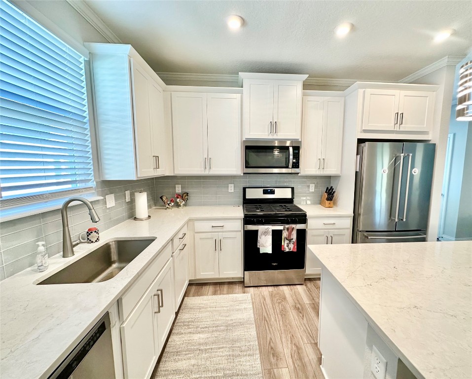 323 Sweetgum Street Yulee, FL 32097 - Photo 4 of 29 a kitchen with stainless steel appliances granite countertop a sink stove refrigerator and cabinets