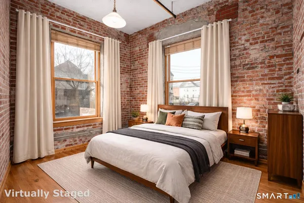 a bedroom with a bed and a large window