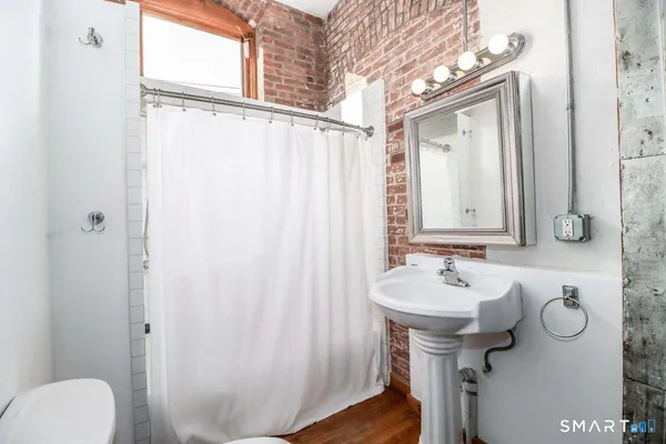 a bathroom with a sink and mirror with toilet