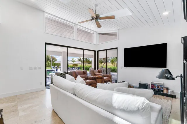 a living room with furniture a floor to ceiling window and a flat screen tv