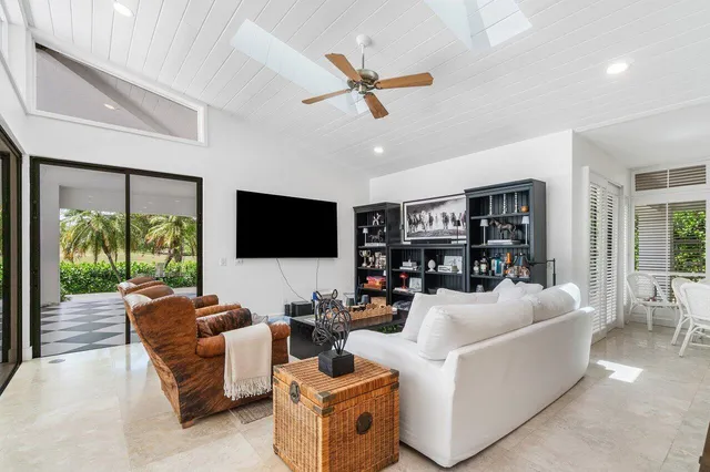a living room with furniture kitchen view and a book shelf