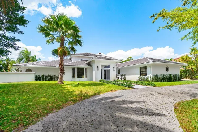 a front view of a house with a yard and trees
