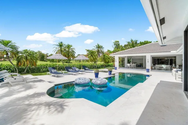 a living room with patio furniture and a large window