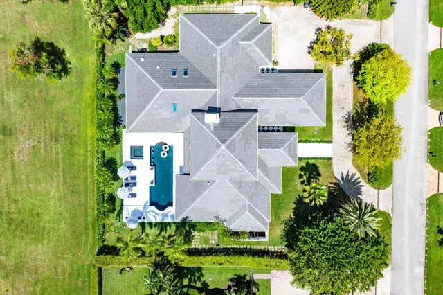 an aerial view of a city with lots of residential buildings ocean and mountain view in back