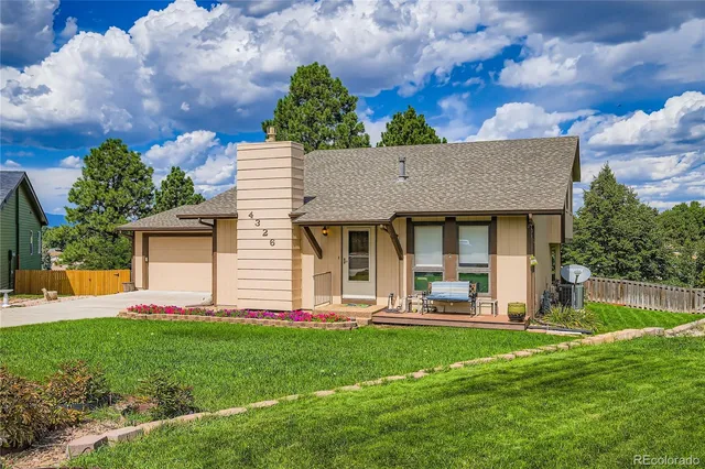 a front view of a house with a yard and green space