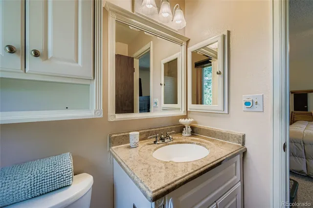 a bathroom with a granite countertop sink and a mirror