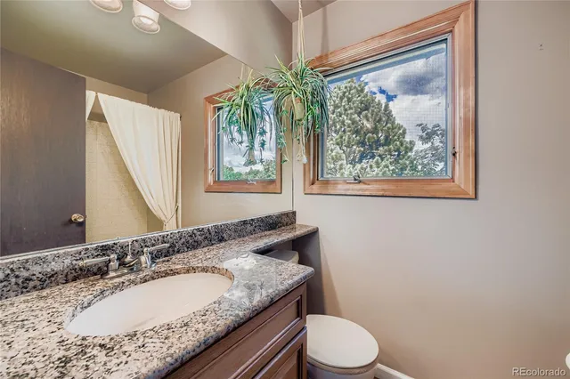 a bathroom with a granite countertop sink and a mirror