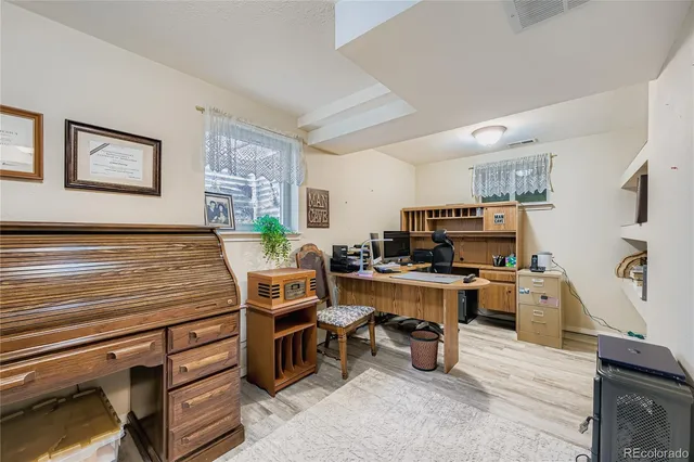 a room with furniture a flat screen tv and kitchen view