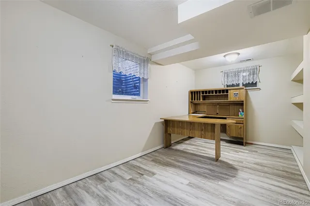 a hallway with a bench and paintings on the wall