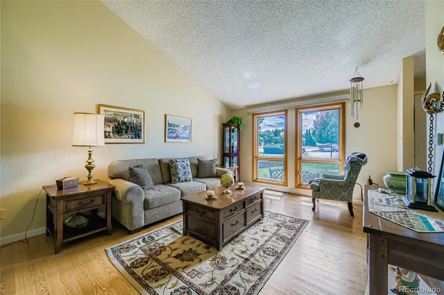 a living room with furniture large window and a table