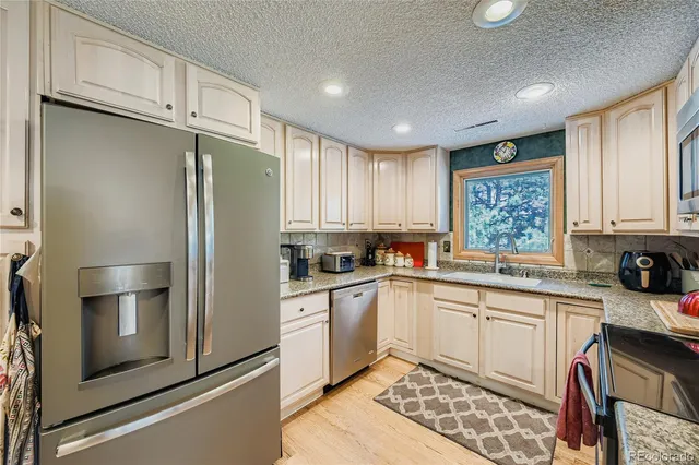 a kitchen with a refrigerator sink and cabinets