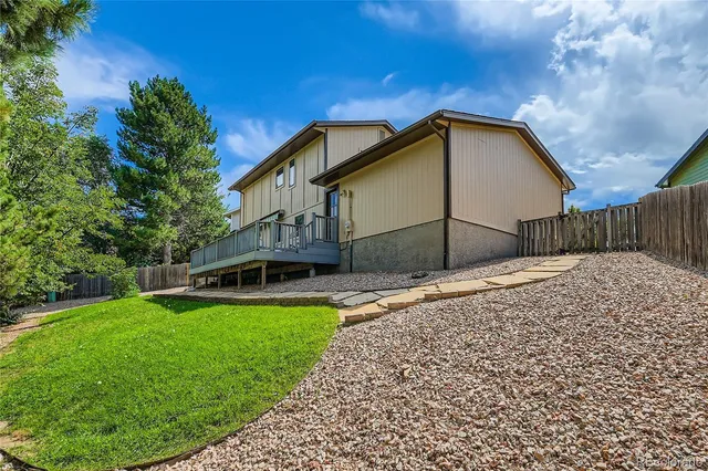 a view of a house with a yard and sitting area