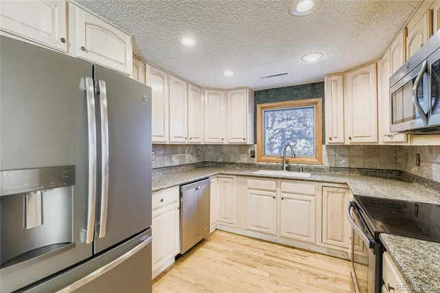 a kitchen with stainless steel appliances granite countertop a refrigerator sink and cabinets