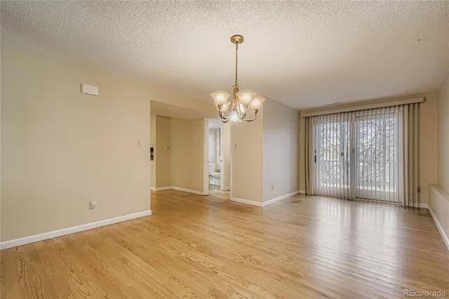 a view of an empty room with chandelier and a window