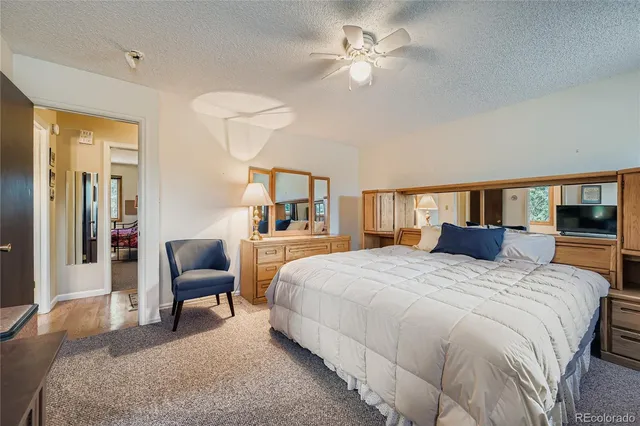 a bedroom with a large bed a chandelier and a dresser