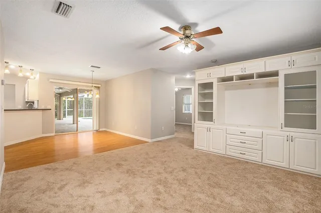 an empty room with cabinet and windows