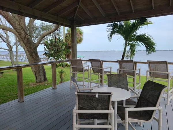 a view of a patio with table and chairs with wooden floor and fence