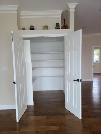 a view of a livingroom with wooden floor and a ceiling fan