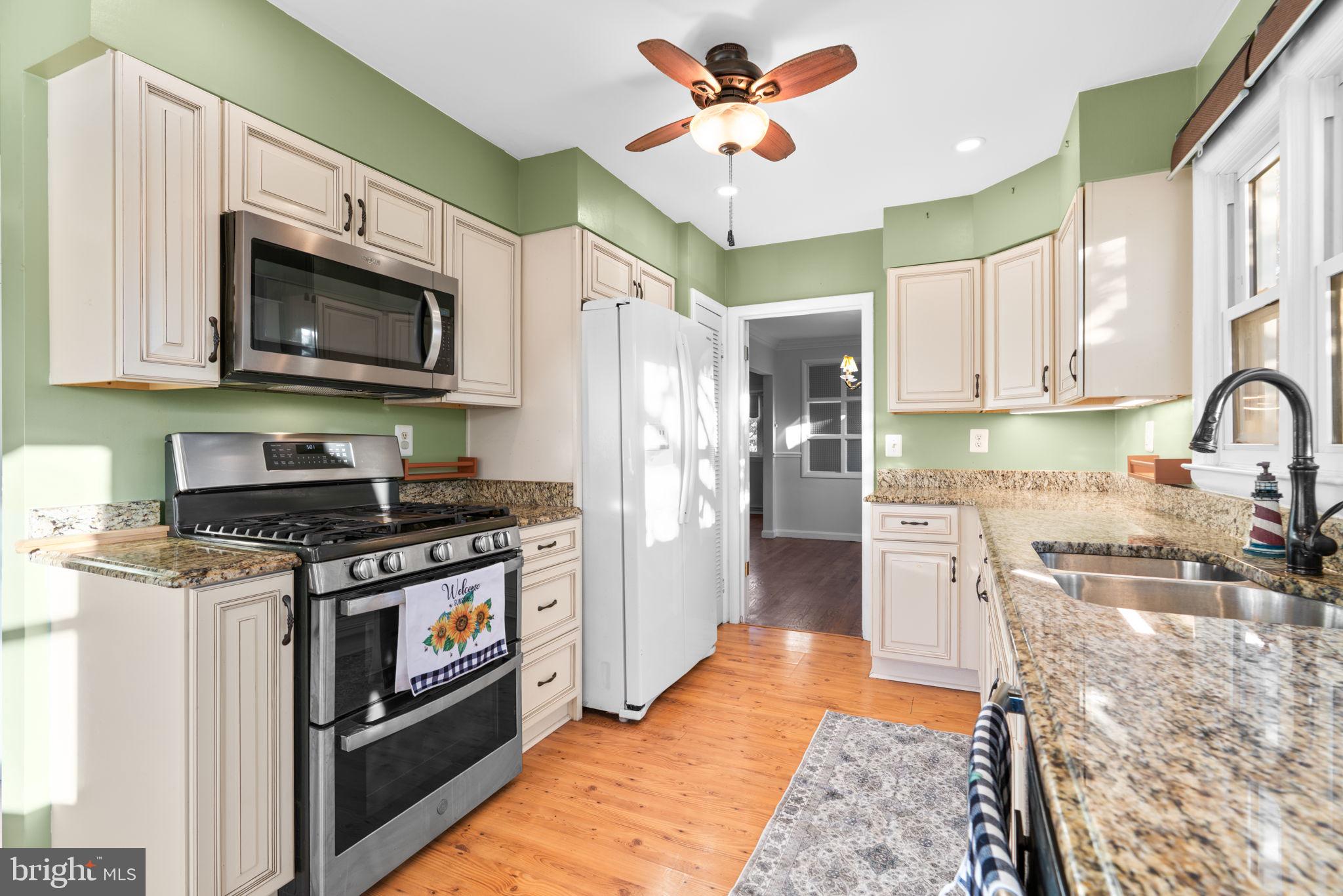 302 Regency Circle Linthicum Heights, MD 21090 - Photo 12 of 33 a kitchen with stainless steel appliances granite countertop a stove a sink and a microwave