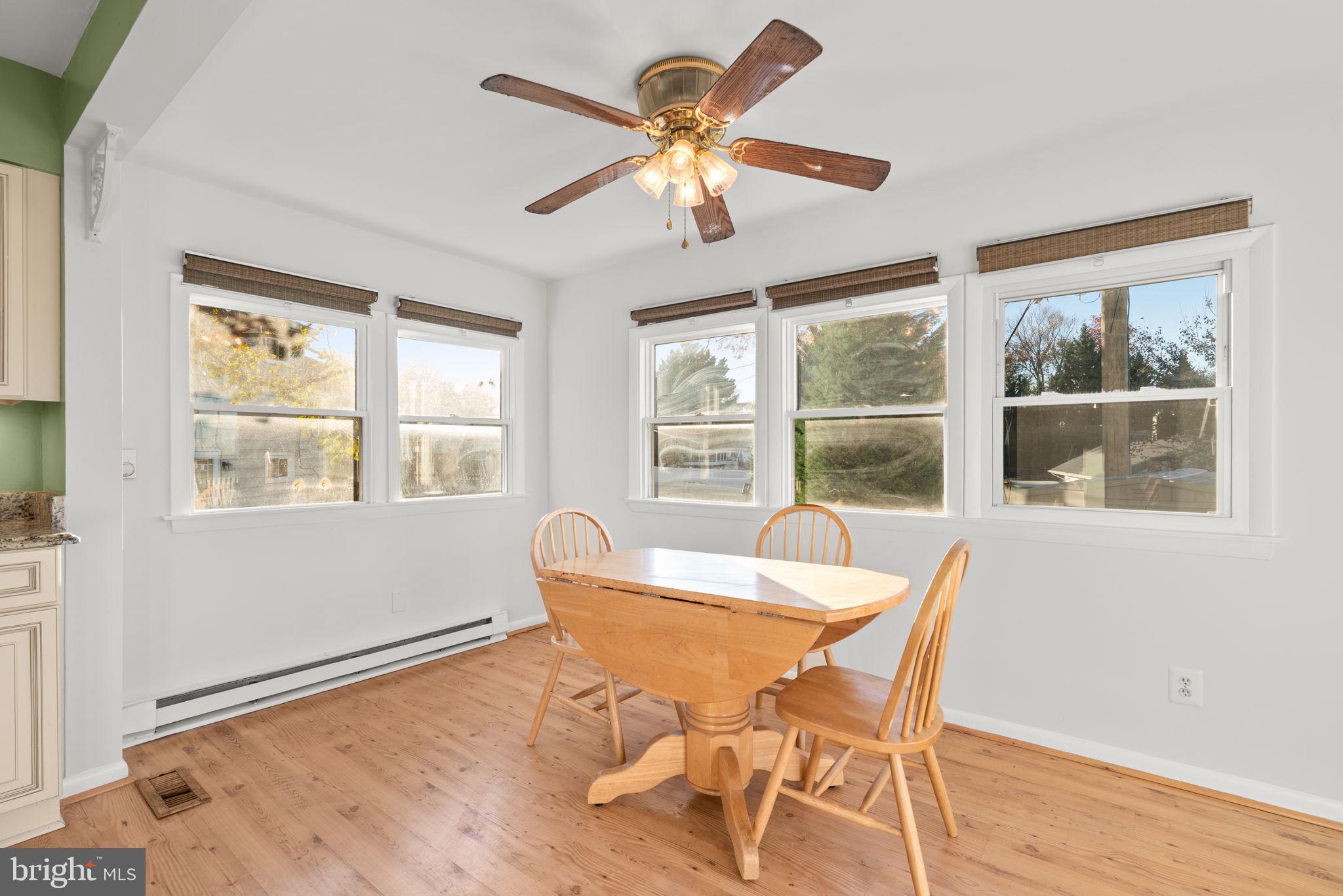302 Regency Circle Linthicum Heights, MD 21090 - Photo 14 of 33 a dining room with wooden floor a chandelier fan a wooden table and chairs