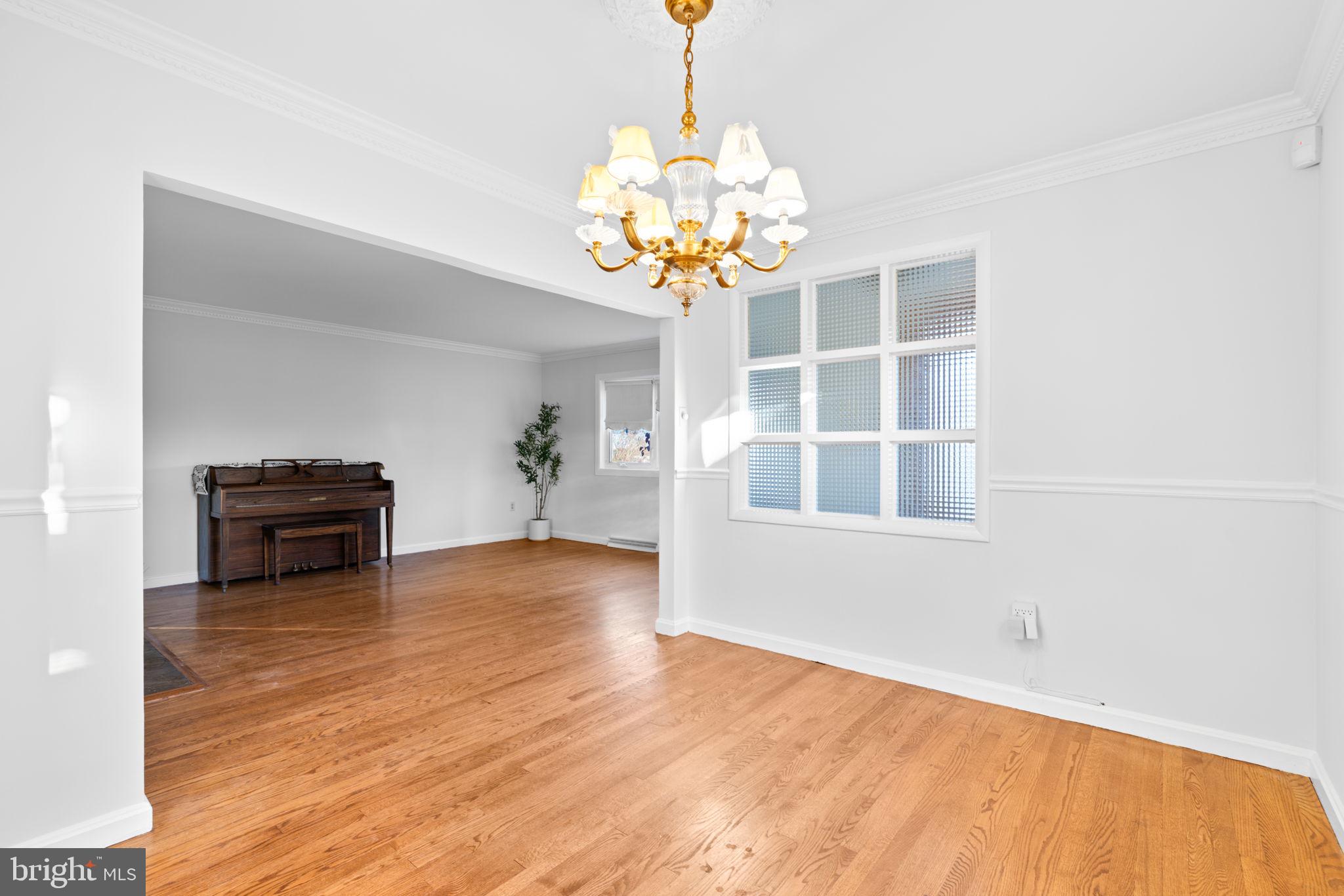 302 Regency Circle Linthicum Heights, MD 21090 - Photo 8 of 33 a view of a room with wooden floor and a chandelier