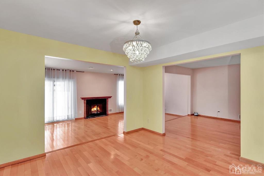 136 Redpine Loop Old Bridge, NJ 08857 - Photo 7 of 22 a view of a livingroom with a fireplace a chandelier and wooden floor