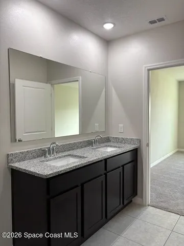 a bathroom with a granite countertop sink a toilet and mirror