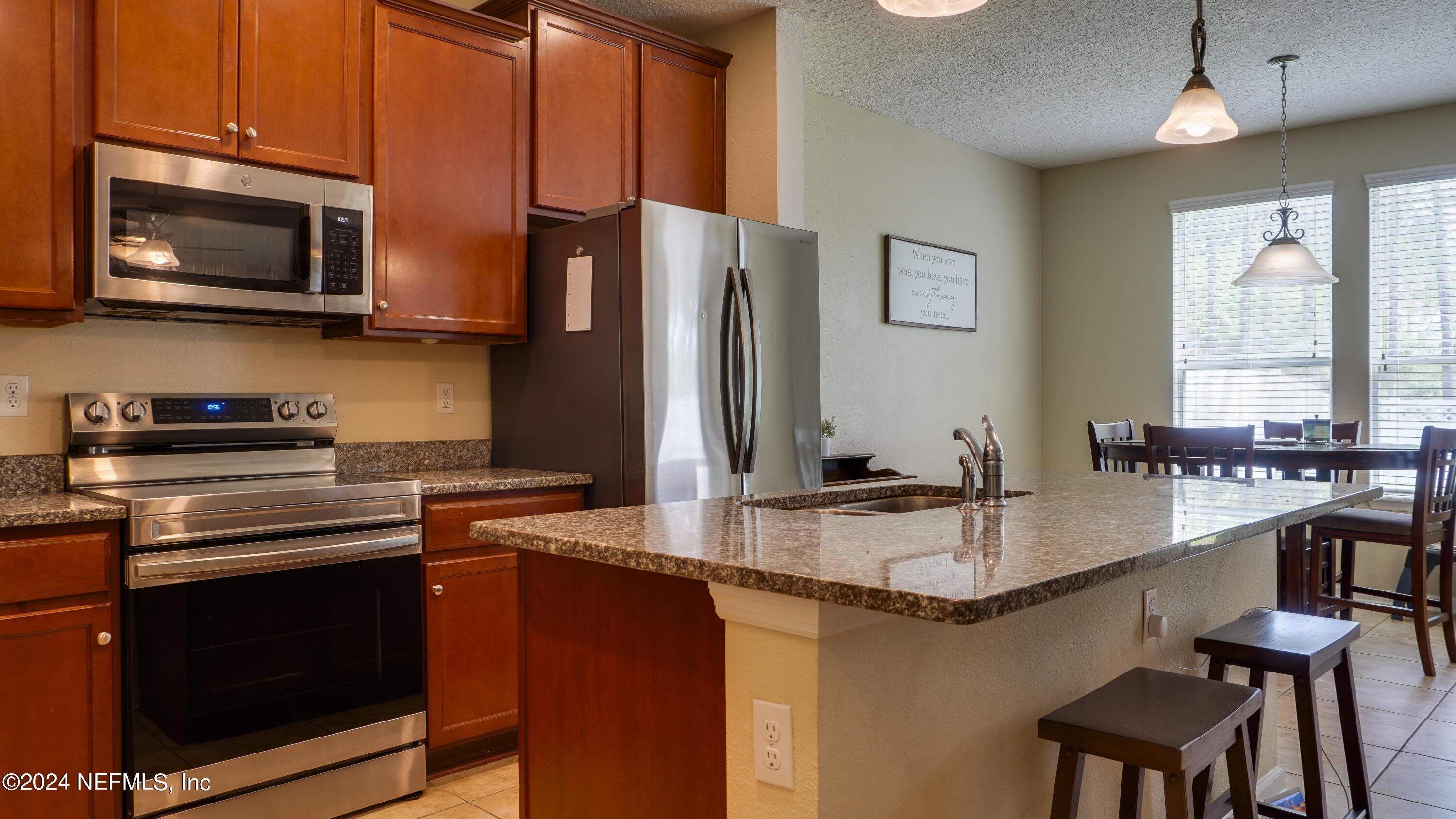 3838 Chasing Falls Road Orange Park, FL 32065 - Photo 8 of 33 a kitchen with stainless steel appliances granite countertop a stove microwave and sink