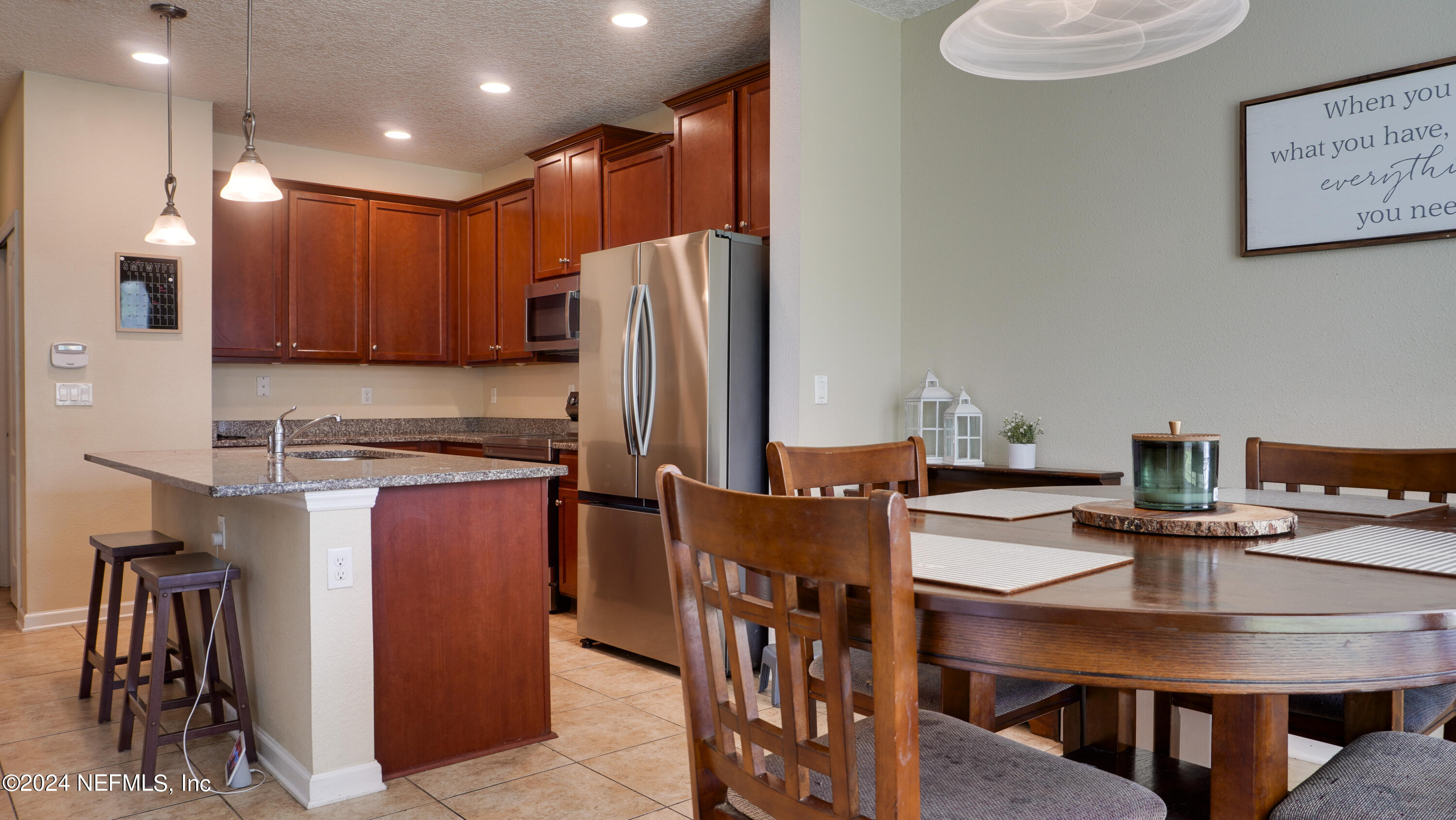 3838 Chasing Falls Road Orange Park, FL 32065 - Photo 10 of 33 a kitchen with stainless steel appliances granite countertop a refrigerator a stove a sink a dining table and chairs with wooden floor