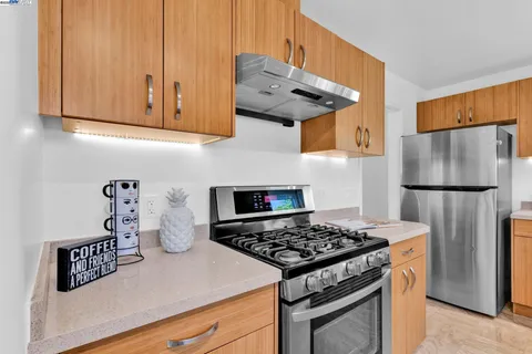 a kitchen with stainless steel appliances granite countertop a sink stove and cabinets