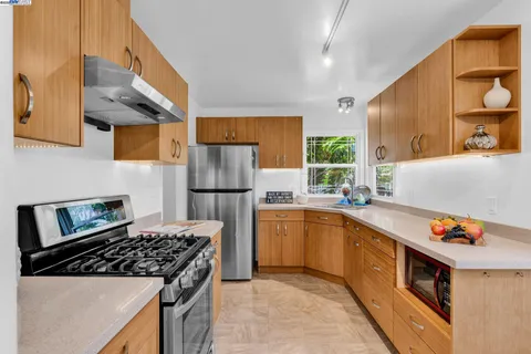 a kitchen with stainless steel appliances granite countertop a sink stove and refrigerator