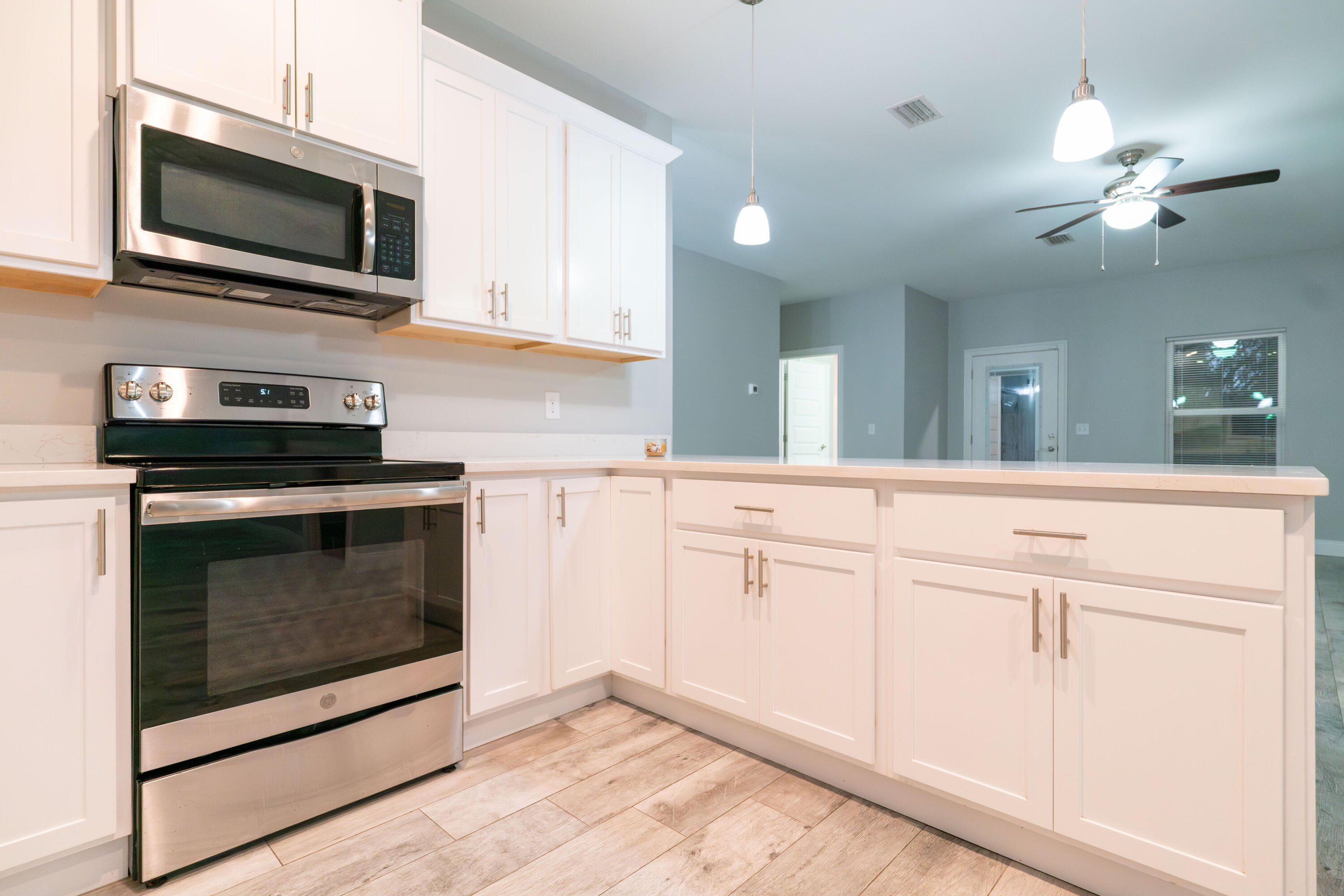 2243 Wind Trace Road North Navarre, FL 32566 - Photo 12 of 34 a kitchen with white cabinets stainless steel appliances and sink