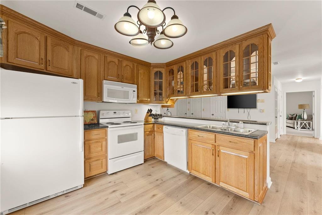 103 Tugalo Point Lavonia, GA 30553 - Photo 44 of 70 a kitchen with stainless steel appliances granite countertop a stove top oven a refrigerator a sink and dishwasher with wooden floor