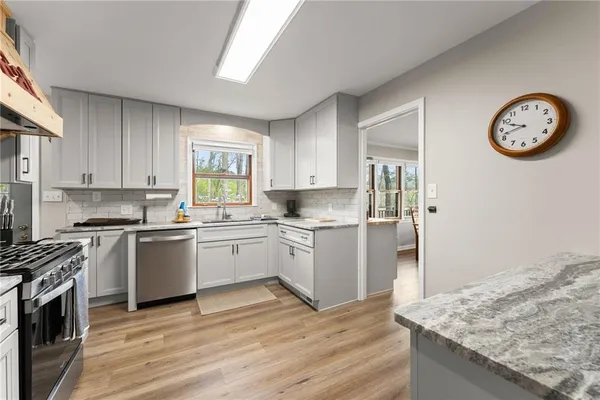 a kitchen with a refrigerator a stove a sink and a window